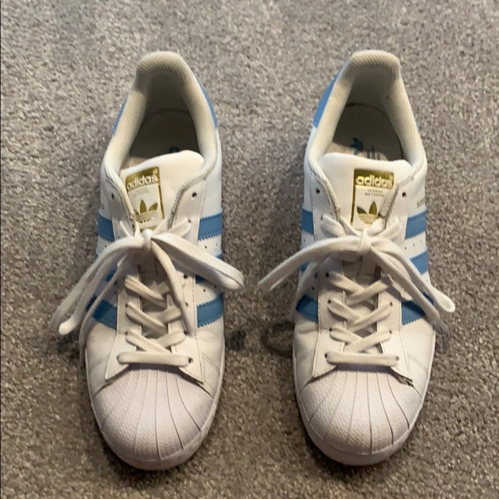 White Adidas superstars with blue stripes